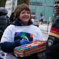 Volunteer carrying a birthday cake on outreach